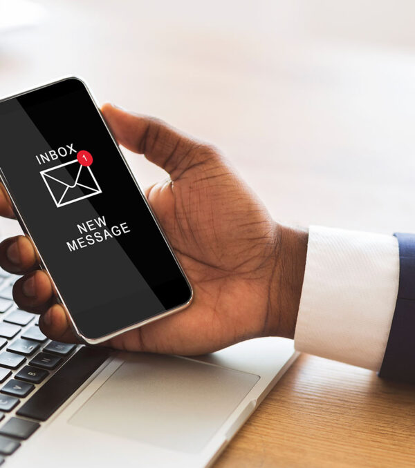 Black Businessman Holding Smartphone Reading E-Mail Message In Office Online Communication. Black Businessman Holding Smartphone Reading New E-Mail Message Sitting At Workplace In Office. Business Networking, Mail Application Concept. Cropped, Closeup