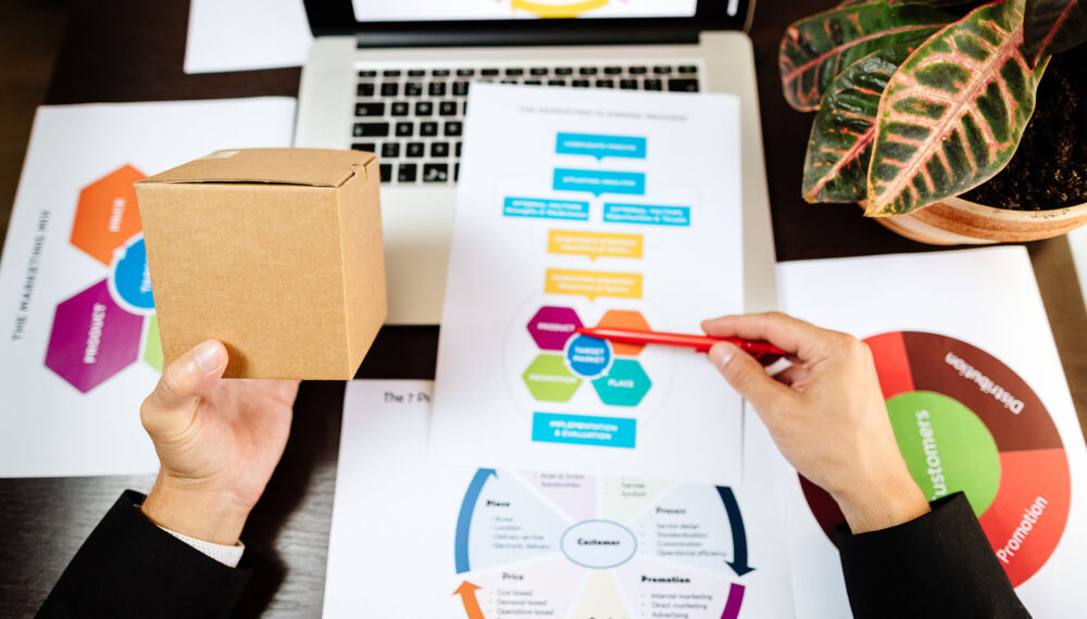 product marketing manager making marketing strategy for new product. Manager holding new product and developing new marketing strategy plan for customers.